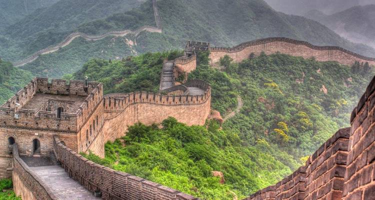 La Grande Muraille de Chine serpentant sur des collines verdoyantes.
