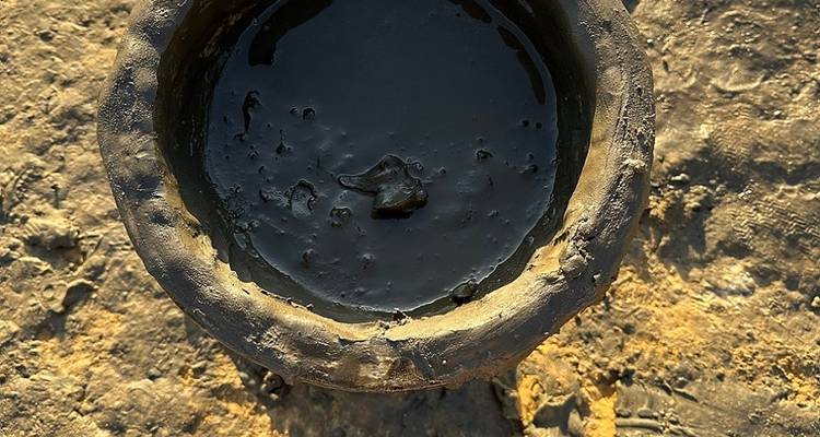 Close-up of a pot with black liquid inside.