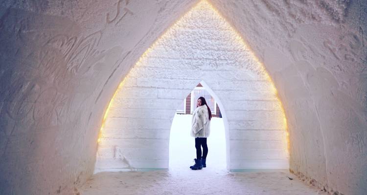 Femme debout dans une structure de glace illuminée.