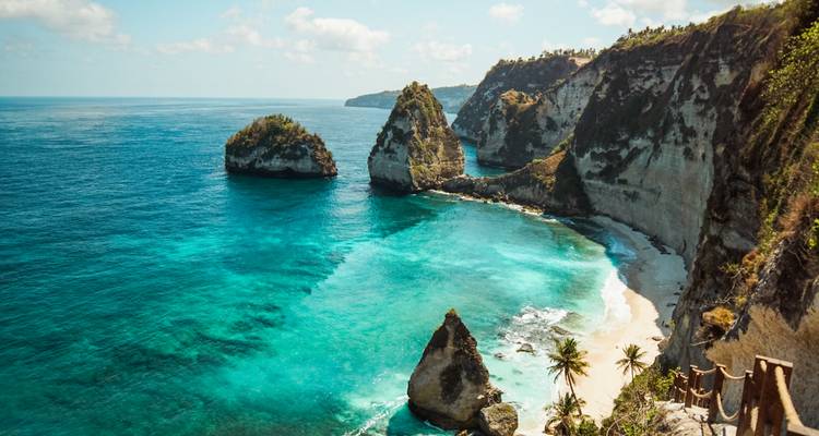 Falaises côtières spectaculaires avec eau turquoise et ciel bleu vif.