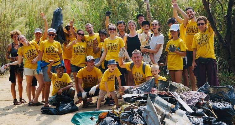 Grote groep mensen verkleed als 'afvalhelden' die buiten zitten