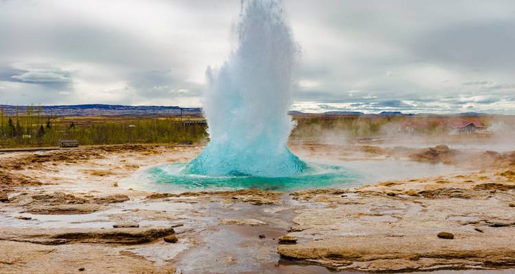 Geyser erupting with water spraying into the sky.