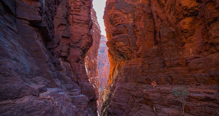 Gorge étroite avec de hautes parois rocheuses rouges de chaque côté.