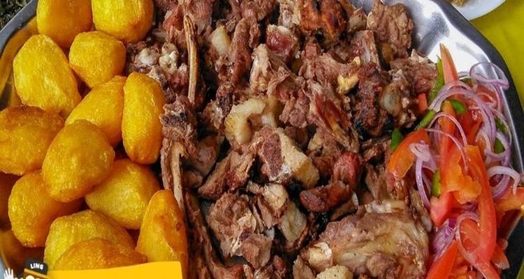 Bord met gebakken aardappelen, vlees en groenten.