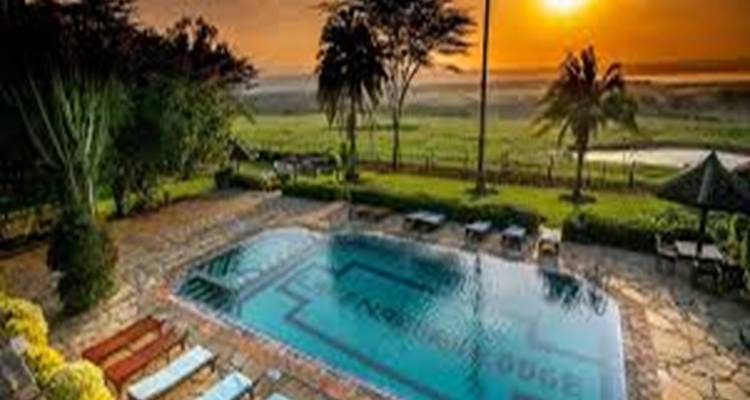 Piscine avec vue sur un coucher de soleil au-dessus d'une savane.