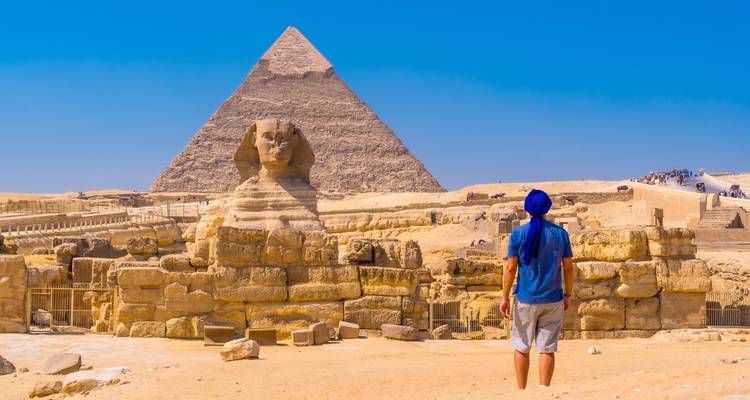 Le Sphinx et la Pyramide de Gizeh avec une personne qui les contemple.
