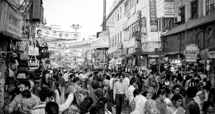 Rue de marché bondée avec une variété de boutiques et d'enseignes.