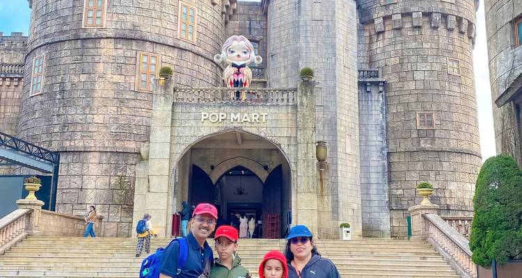Familia posando frente a un edificio parecido a un castillo.