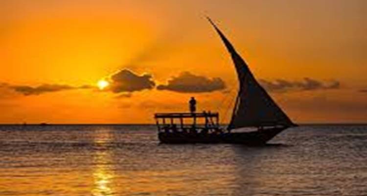 Boot mit Segel bei Sonnenuntergang auf dem Ozean