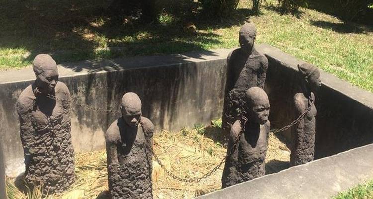 Statuen, die aneinandergekettete Figuren in einem Denkmal darstellen.