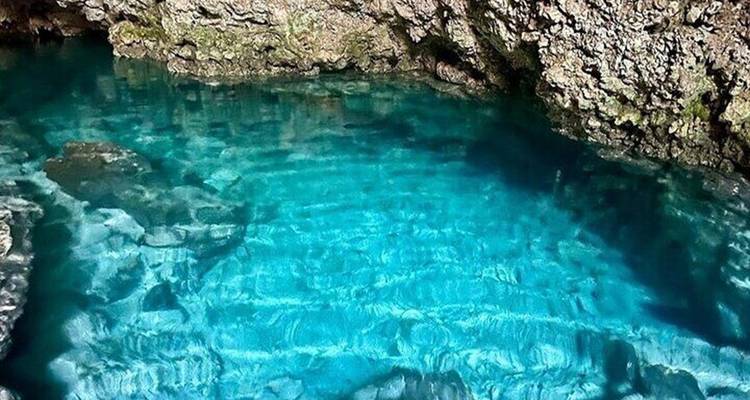 Clear blue water in a natural rocky pool.
