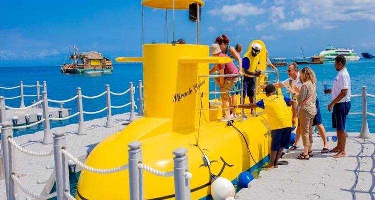 Groep mensen die aan boord gaan van een gele onderzeeër.