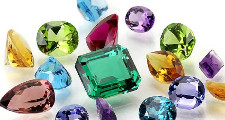 Diverse kleurrijke, gepolijste edelstenen bij elkaar gegroepeerd.