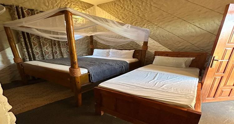 Interieur van een kamer met twee bedden en muskietennet.