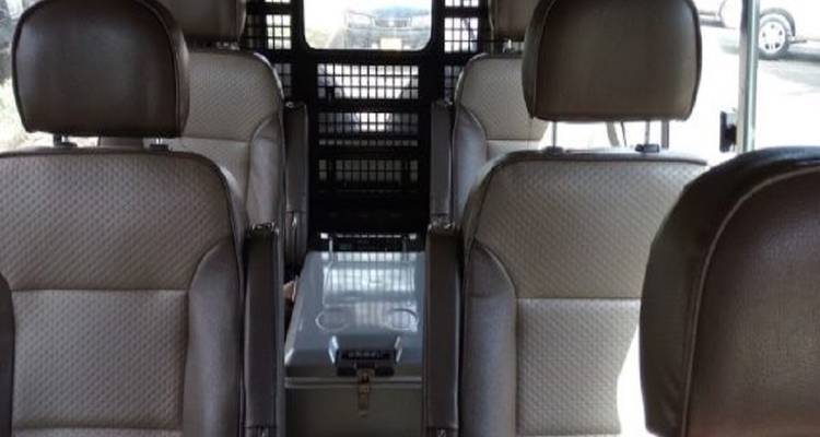 Het interieur van een busje met passagiersstoelen.