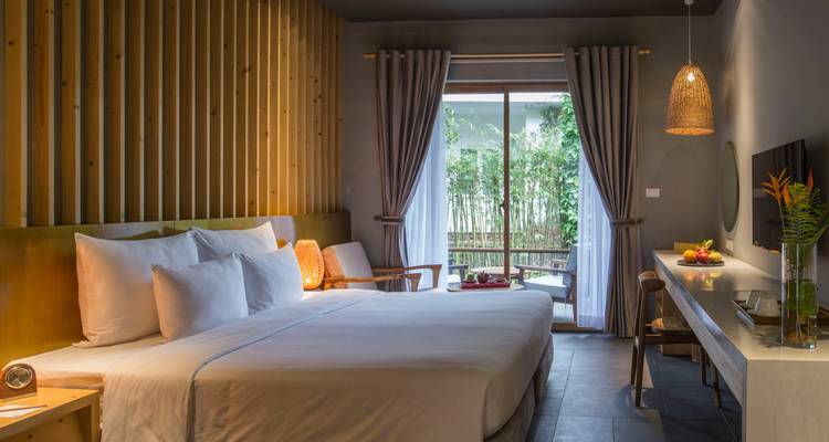 Modern hotel room with a double bed and natural light.