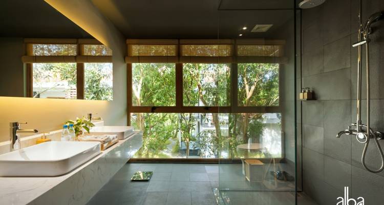 Modern bathroom with large window and nature outside.