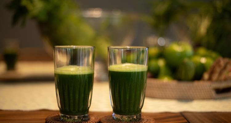 Glasses of green juice on a table.