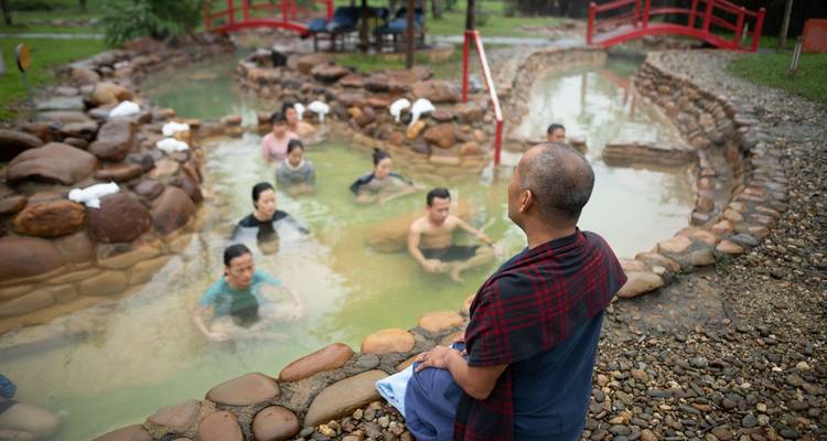 Group of people relaxing in a hot spring outdoors.