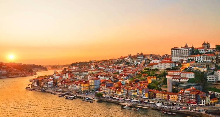 Puesta de sol dorada sobre los coloridos edificios de las laderas de Oporto a lo largo del río Duero.