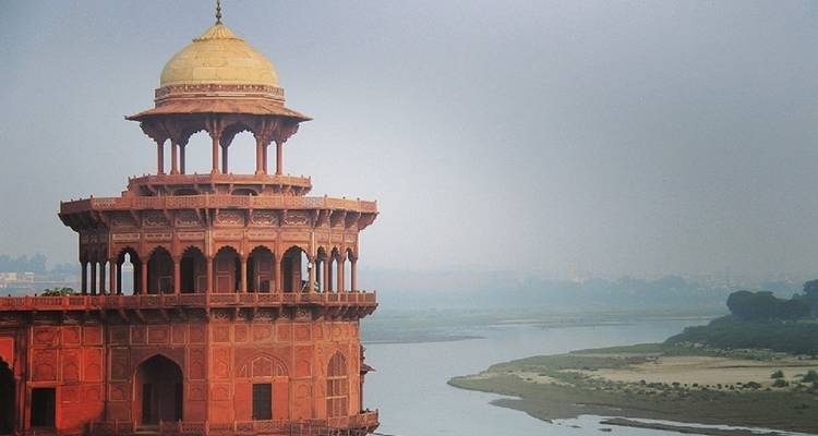 Red sandstone pavilion overlooking a river.