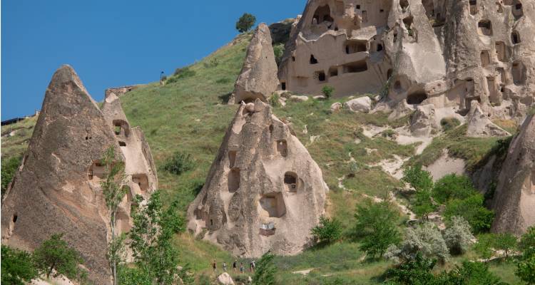 Formations rocheuses avec des fenêtres sculptées dans un flanc de colline.