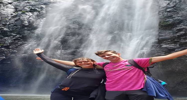 Twee mensen die gelukkig poseren voor een waterval