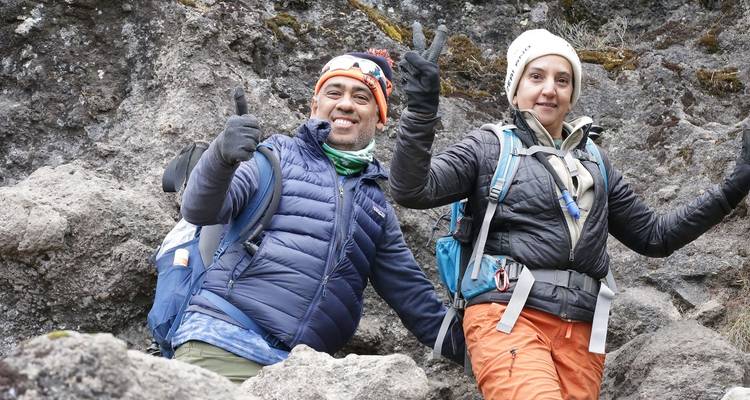 Twee mensen die glimlachen en een duim omhoog geven tijdens een wandeling