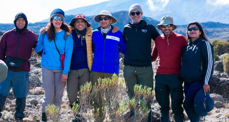 Een groep wandelaars die poseert voor een foto in een bergachtig gebied
