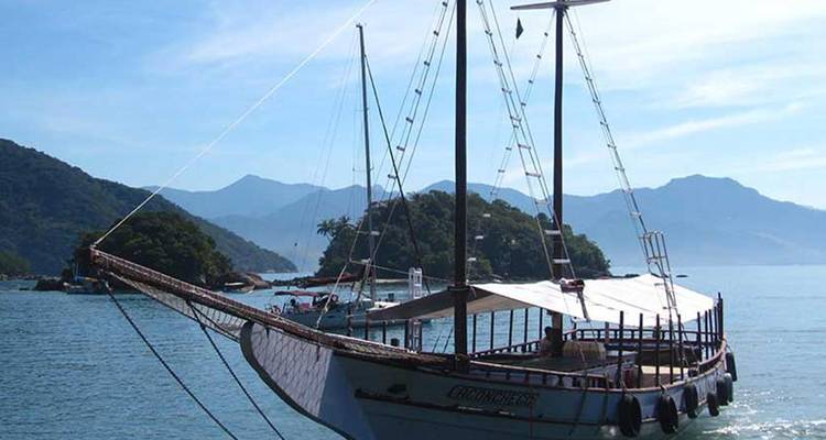 Traditionele boot in een rustige baai met weelderige heuvels op de achtergrond.
