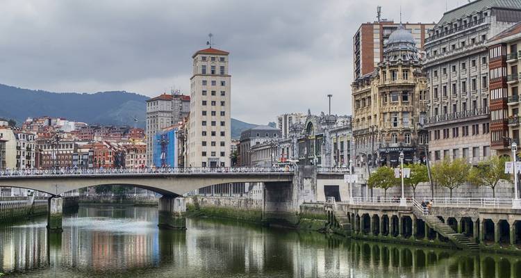 Paisaje urbano de Bilbao con un río y edificios históricos.
