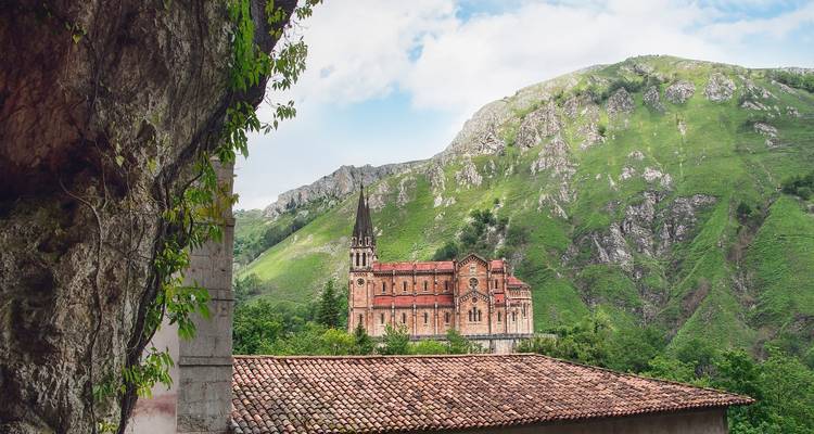 Basílica situada contra un exuberante telón de fondo montañoso y verde.