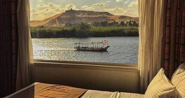 Vista de un río desde una ventana con un pequeño bote a lo lejos.