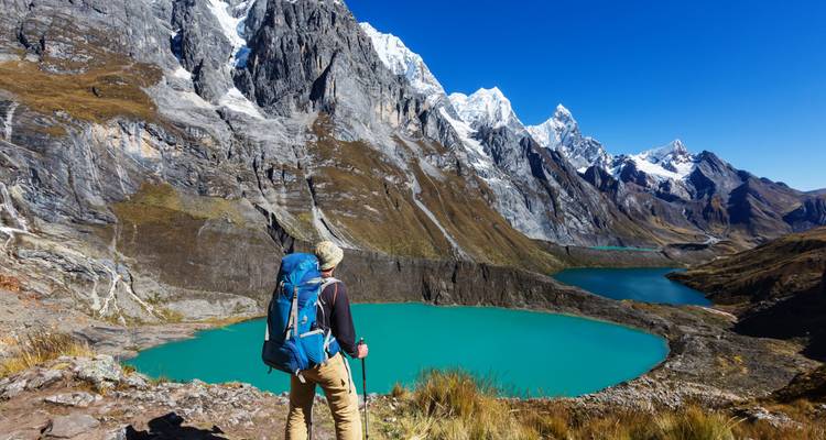 Wandelaar met uitzicht op turkooizen meren in de Andes.