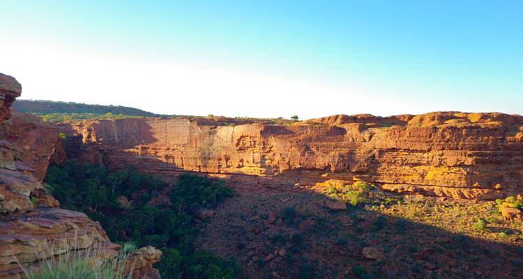 Muros de arenisca iluminados por el sol en Kings Canyon con un desfiladero profundo y sombrío abajo