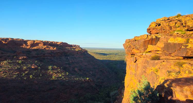 La lumière dorée illuminant le bord abrupt de la falaise de Kings Canyon avec la vaste plaine de l'arrière-pays au-delà