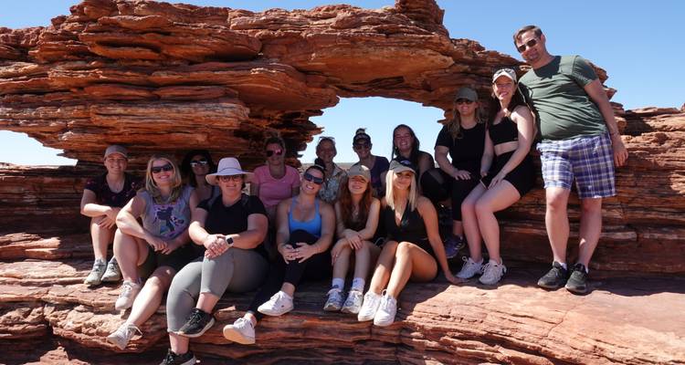 Large tour group posing under the natural rock arch known as Nature’s Window in Kalbarri National Park.