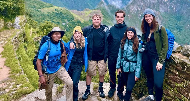 Eine Gruppe von Wanderern, die vor einer malerischen Bergkulisse posiert.