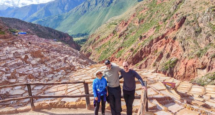 Trois personnes posant avec une vue panoramique des mines de sel.