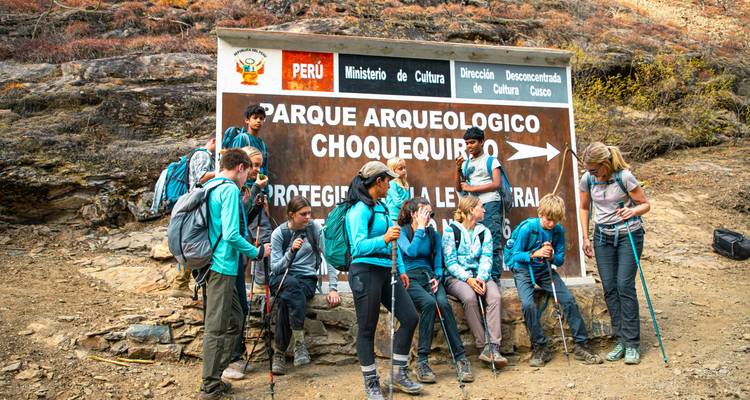 Groupe de randonneurs rassemblés devant un panneau pour Choquequirao.