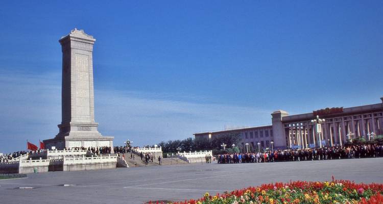 Place Tiananmen avec un grand monument et une foule.