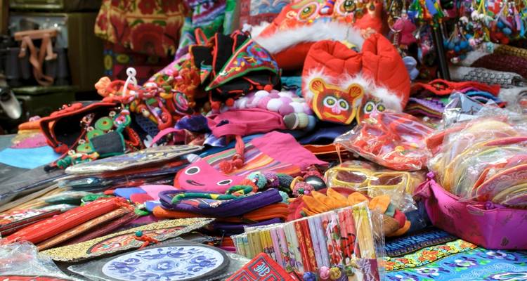 Étal de marché coloré avec des textiles traditionnels et des souvenirs.