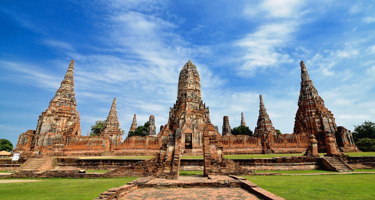 Ancient temple complex with tall spires under a blue sky.
