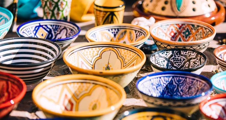 Een assortiment van kleurrijke handgeschilderde keramische kommen in de etalage.