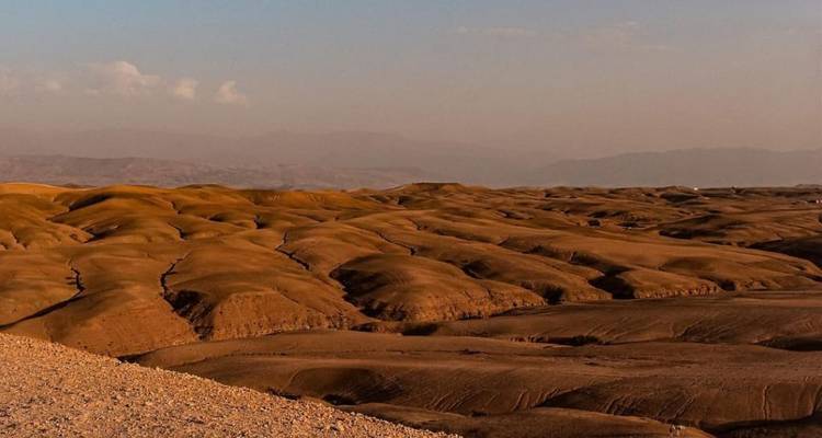 Woestijnlandschap met glooiende heuvels and bergen.
