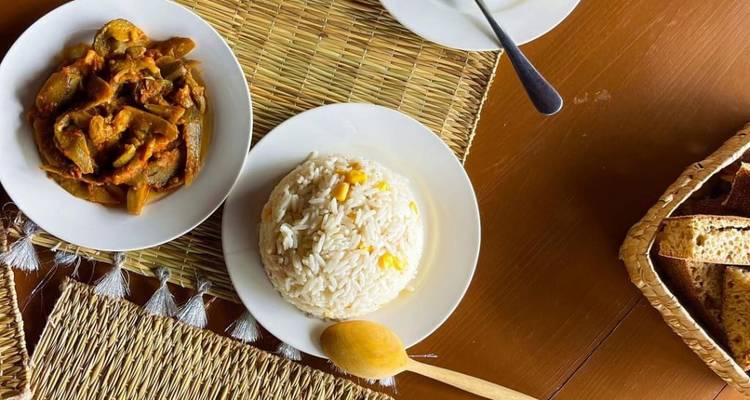 Traditionele maaltijd met rijst en stoofschotel op gevlochten placemats.