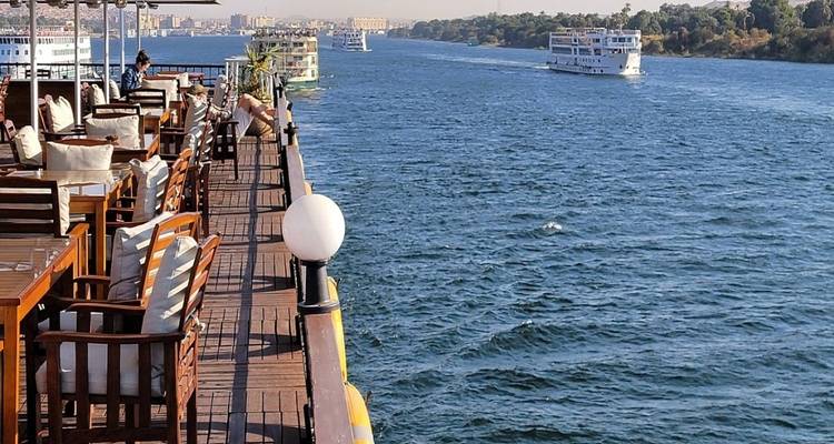 Uitzicht vanaf een bootdek op een rivier met andere vaartuigen in de verte.