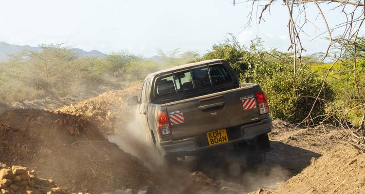 Ein Toyota-Lastwagen, der auf einem Feldweg fährt.