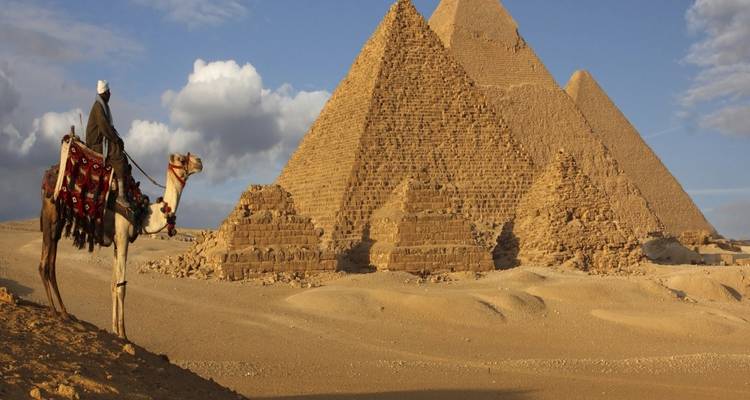 Pyramids of Giza with a camel rider in the foreground.