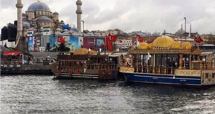 Traditionele Turkse boten op de Bosporus met een moskee op de achtergrond.